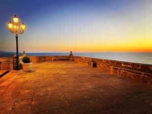 a street light next to the ocean at sunset at Residenza Matilde in Fiumefreddo Bruzio