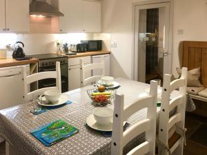 a kitchen with a table with a bowl of fruit on it at The Apostles in Catacol
