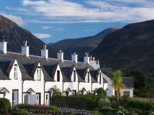 a row of white houses with mountains in the background at The Apostles in Catacol