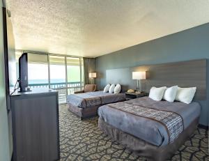 a hotel room with two beds and a balcony at Seaview Hotel in Virginia Beach