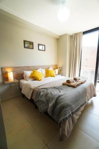 um quarto com uma cama grande e almofadas amarelas em Rent for Days IV- Norte Vip em San Miguel de Tucumán