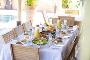 una mesa larga con platos de comida. en Maria Towers , Palais Table d'hôtes & SPA, en Marrakech
