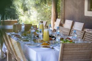 un tavolo con piatti di cibo e bottiglie d'acqua di Maria Towers , Palais Table d'hôtes & SPA a Marrakech