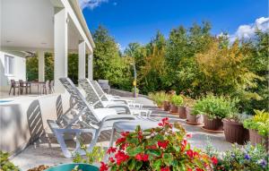 a row of chairs and tables on a patio with flowers at Lovely Home In Zminj With Kitchen in Žminj