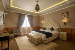 馬拉喀什的住宿－Maria Towers , Palais Table d'hôtes & SPA，一间卧室配有一张床、一张沙发和一张桌子