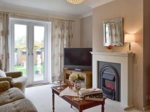 a living room with a fireplace and a tv at The Warren in Seasalter