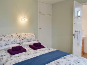 a bedroom with a bed with purple towels on it at The Warren in Seasalter