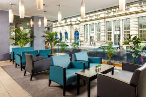 a restaurant with blue chairs and tables in front of a building at Mercure Glasgow City Hotel in Glasgow