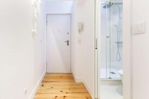 a white bathroom with a shower and a toilet at Charming Santos by Homing in Lisbon