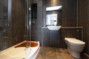 a bathroom with a tub and a sink and a toilet at ALTIDO Stylish 2-bed flat in New Town in Edinburgh