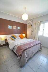1 dormitorio con cama grande y ventana grande en Rent for Days II - Top Centro en San Miguel de Tucumán