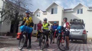 a group of people on bikes in front of a house at Snow Leopard Hostel in Karakol