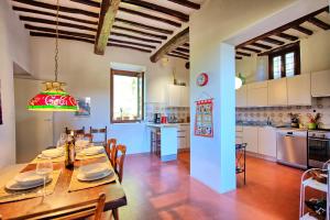 een keuken en eetkamer met een tafel en stoelen bij Villa Ulivacci by PosarelliVillas in Cavriglia