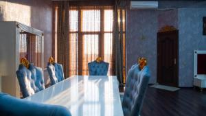 Baku Entire Villa في باكو: قاعة اجتماعات مع طاولة كبيرة وكراسي زرقاء
