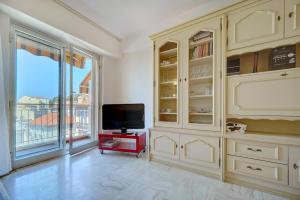 a living room with a tv and a large window at 2 room center very comfortable wi fi in Cannes