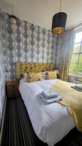 1 dormitorio con 1 cama blanca grande y papel pintado de color azul en BLACKBURNE ARMS ,24 CATHARINE STREET HOTEL, en Liverpool