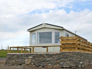 een huisje op een stenen muur bij Neuadd Wen Cottages - Porthdy Crey R Wen in Llanfachraeth