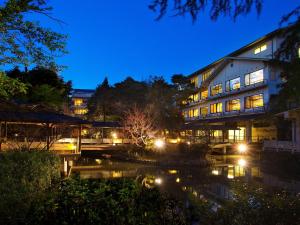 a building at night with a river in front of it at Matsusaki in Nomi