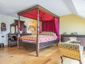 Cinderford的住宿－Paradise，一间卧室配有一张天蓬床和一把椅子
