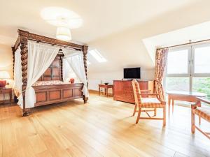 1 dormitorio con cama con dosel, mesa y sillas en Paradise, en Cinderford