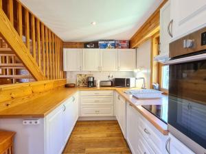 a kitchen with white cabinets and a counter top at Chalet spacieux à Flaine avec sauna, cheminée et balcon - 6 chambres, proche des pistes - FR-1-425-4 in Flaine +15 photos