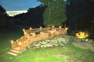 a wooden deck with lights on the grass at night at Landhouse in Olofström