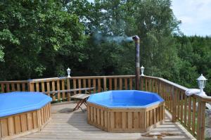 a hot tub on a wooden deck with a grill at Landhouse in Olofström