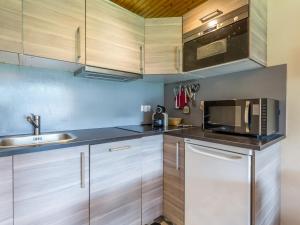 a kitchen with wooden cabinets and a microwave at Appartement La Clusaz, 3 pièces, 6 personnes - FR-1-437-59 in La Clusaz
