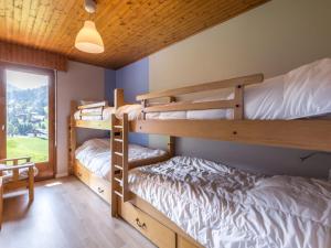 two bunk beds in a room with a window at Appartement La Clusaz, 3 pièces, 6 personnes - FR-1-437-59 in La Clusaz