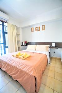 a bedroom with a large bed with yellow towels on it at Rent for Days III - Mono Plaza in San Miguel de Tucumán