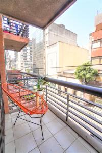 una silla naranja sentada en el balcón de un edificio en Rent for Days III - Mono Plaza en San Miguel de Tucumán