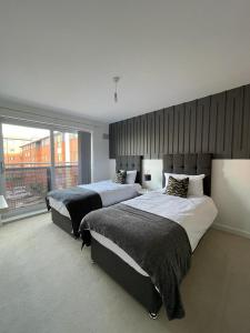 a bedroom with two beds and a large window at Grand Station Suite in Wolverhampton