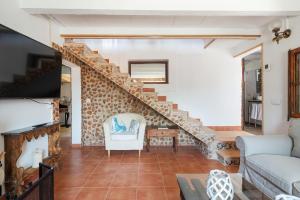 uma sala de estar com uma escada e um sofá em Sa Caseta -Ca n'Andreu- em Santa Maria del Camí