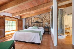 um quarto com uma cama num quarto com tectos em madeira em Sa Caseta -Ca n'Andreu- em Santa Maria del Camí