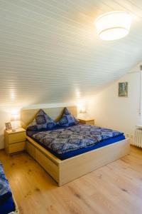 um quarto com uma cama com um edredão azul em Ferienwohnungen Am Skilift em Herrischried