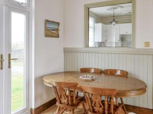 a dining room table with chairs and a mirror at Craig Hall in Drummore