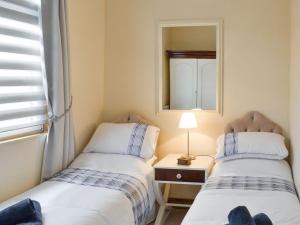 two beds in a small room with a mirror at Craig Hall in Drummore