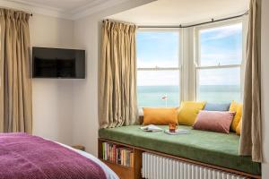 a bedroom with a window seat with a view of the ocean at Fort Road Hotel in Margate