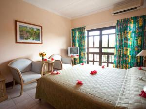 a bedroom with a large bed with flowers on it at Gregoire's Apartment in La Digue