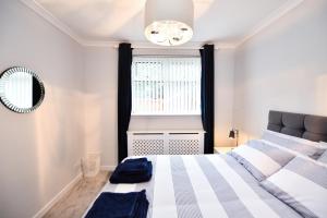 a bedroom with a bed and a mirror and a window at Sea Star in Troon