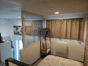 una habitación con una cama y una ventana en L'annexe de l'usine Logement Moderne de campagne, en Saint-Quentin-Lamotte-Croix-au-Bailly