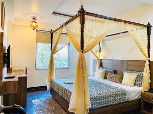 a bedroom with a canopy bed with curtains at Trimrooms Mount Blue in Jaipur
