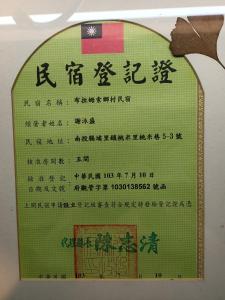 ein Schild mit chinesischer Schrift an der Wand in der Unterkunft Bramasole B&B in Puli
