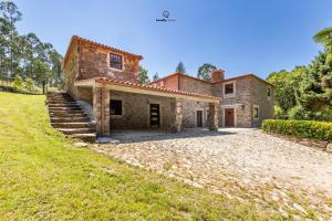 - une vue extérieure sur une maison en pierre avec une cour dans l'établissement Casa do Monte Locally Yours, à Caminha