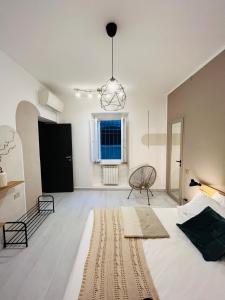 Un dormitorio con una gran cama blanca y una lámpara de araña. en Daisy Homes, en Paderno dʼAdda