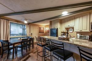 a kitchen with a counter and a table and chairs at Treehouse Lodge at Sugar Mountain in Sugar Mountain +14 photos