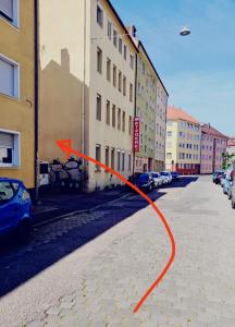 a red arrow on a street next to buildings at VogelsNest in Nürnberg