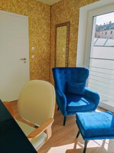 a blue chair and a stool in a room at VogelsNest in Nürnberg
