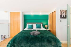 a bedroom with a green headboard and a bed at The Exquisite Duplex of Central Nottingham in Nottingham