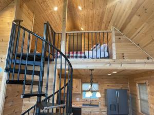 a wooden cabin with a staircase in a room at Cozy 1 bedroom cabin in the heart of Jonesborough in Jonesborough